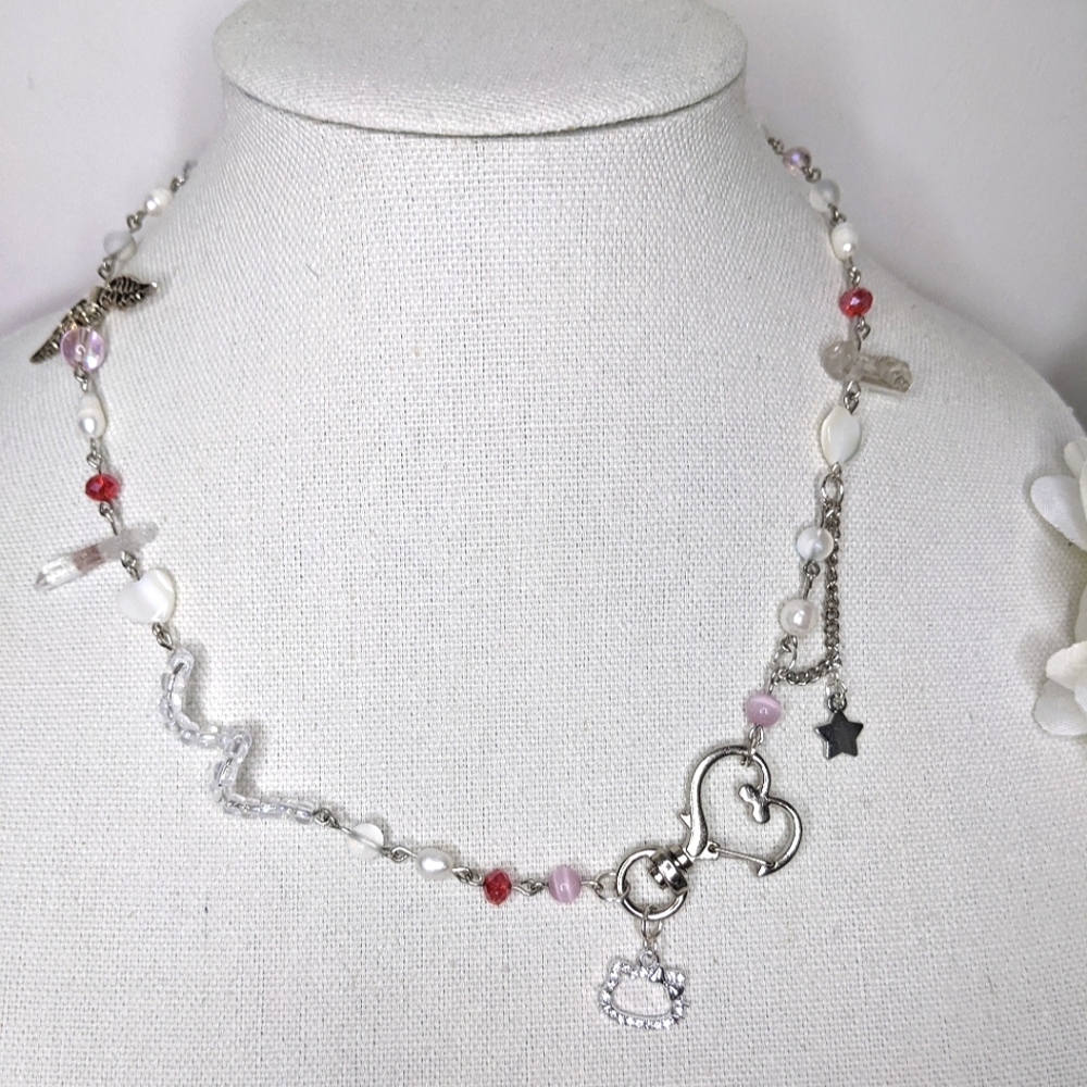 Necklace with red and pink beads a heart charm and chain. Handmade by me.